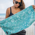 Person holding a green gym towel with sea creatures printed on it