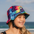 Child wearing a colorful Amity Blue tie-dye bucket hat on a beach